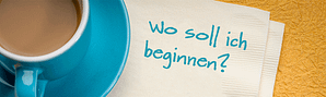 Eine türkise Tasse, weiße Servietten mit dem Text: Wo soll ich beginnen?